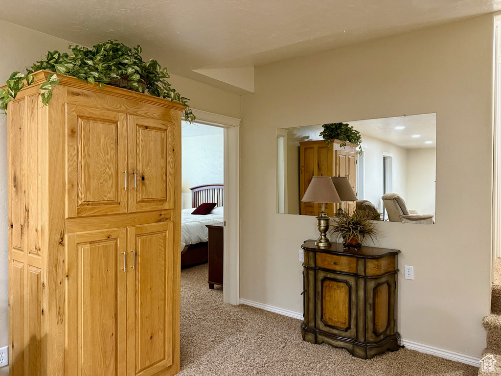Hall featuring light carpet and baseboards
