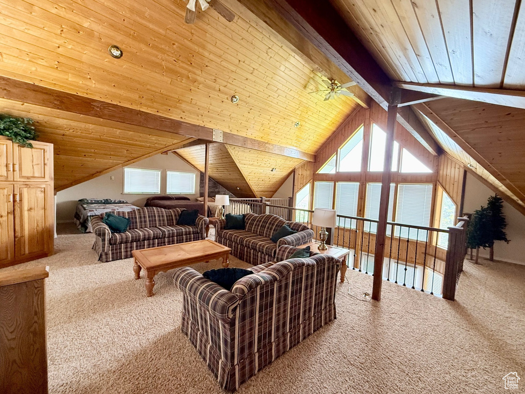 Living area featuring a ceiling fan, carpet flooring, wood ceiling, and plenty of natural light