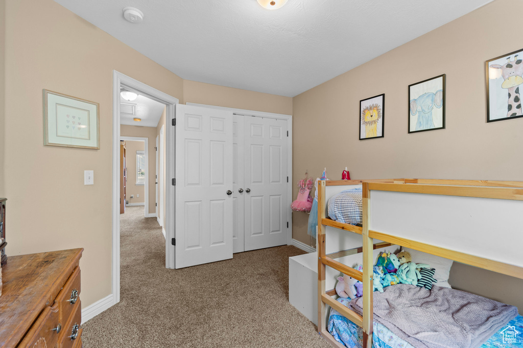 Bedroom featuring carpet, baseboards, and a closet