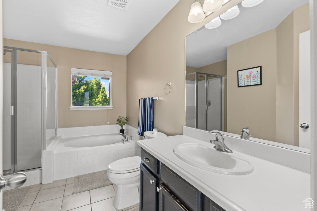 Full bathroom with toilet, tile patterned flooring, vanity, and a stall shower