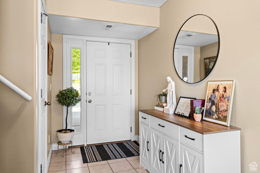 Foyer featuring light tile patterned flooring and baseboards