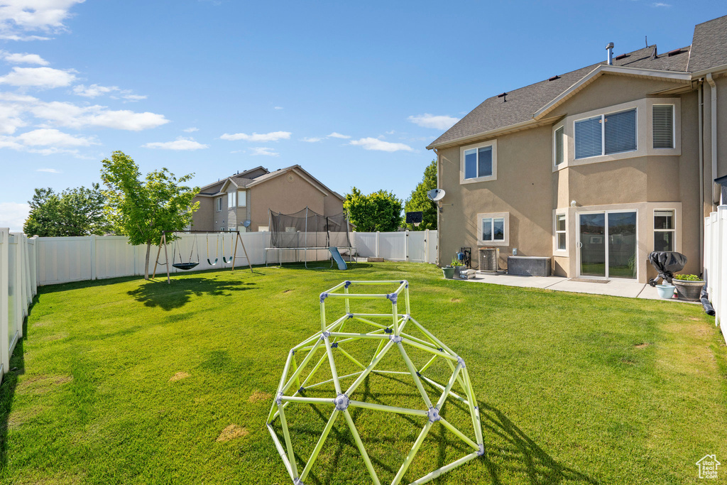 View of yard with a playground, a patio area, central air condition unit, and a trampoline