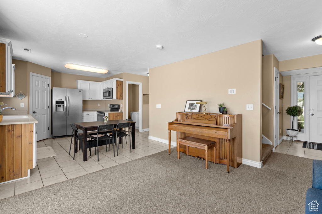 Dining room featuring light tile patterned flooring, light carpet, and baseboards