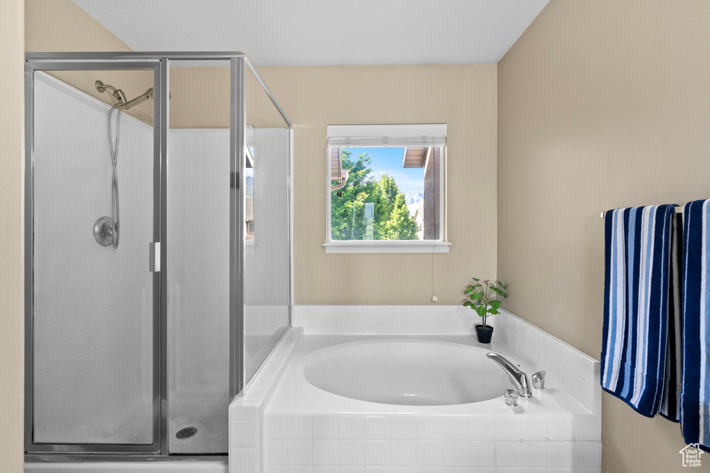 Full bath featuring a stall shower and a bath
