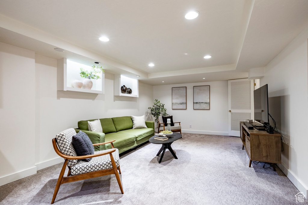 Living area with light colored carpet, recessed lighting, and a tray ceiling