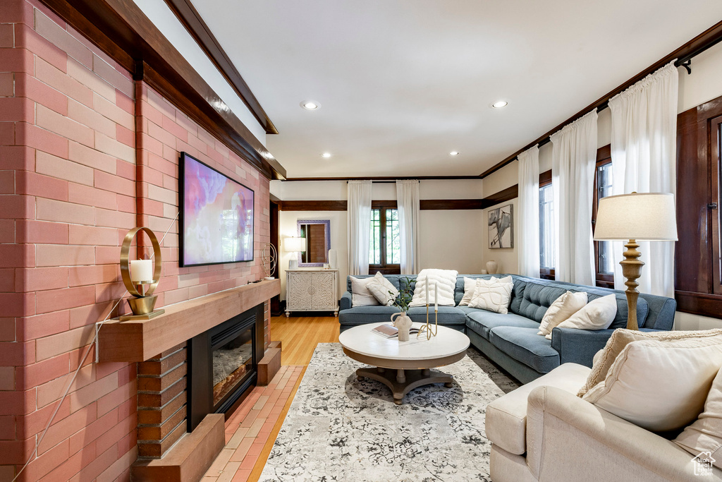 Living area with recessed lighting, crown molding, and a glass covered fireplace