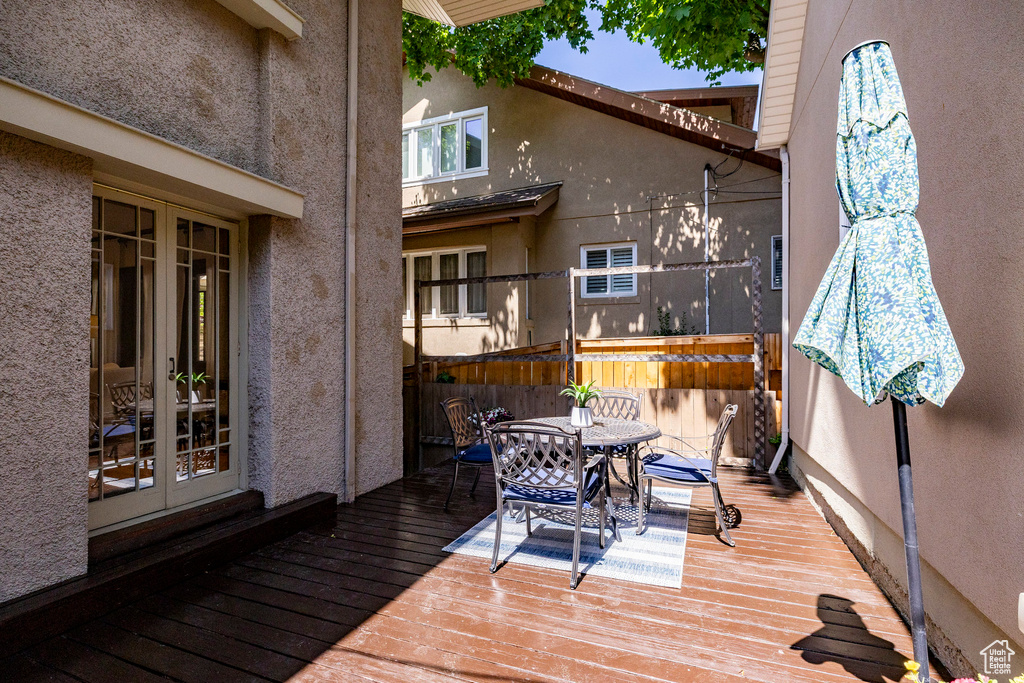 Wooden terrace with outdoor dining space and french doors