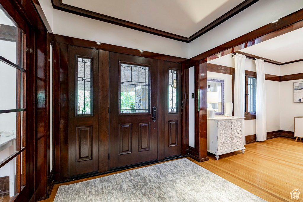 Foyer featuring ornamental molding and wood finished floors