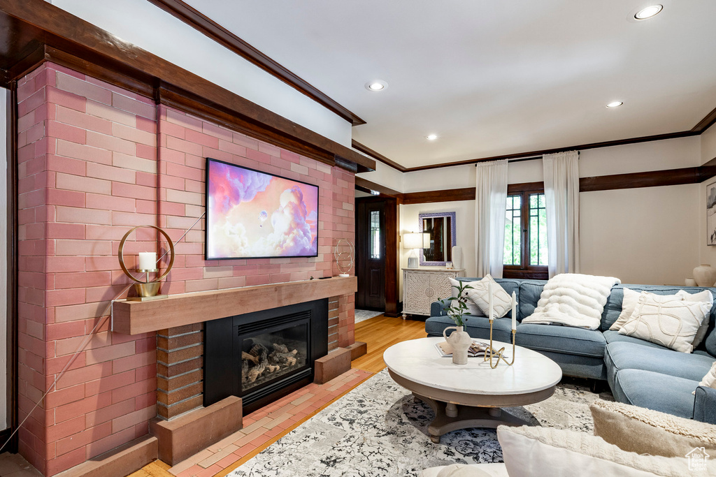 Living area with crown molding, a fireplace, and recessed lighting