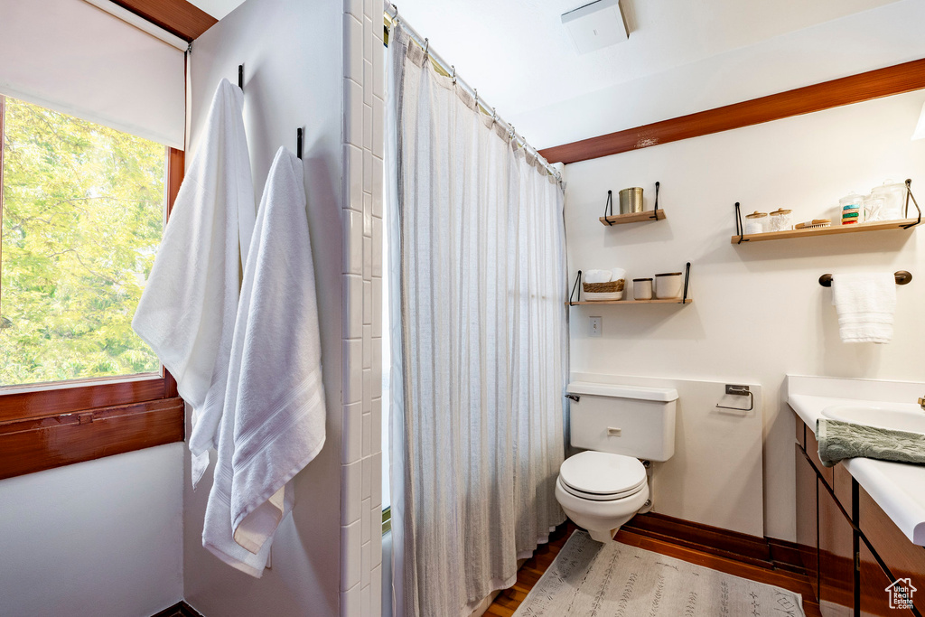 Full bath with vanity, wood finished floors, and shower / bath combo with shower curtain