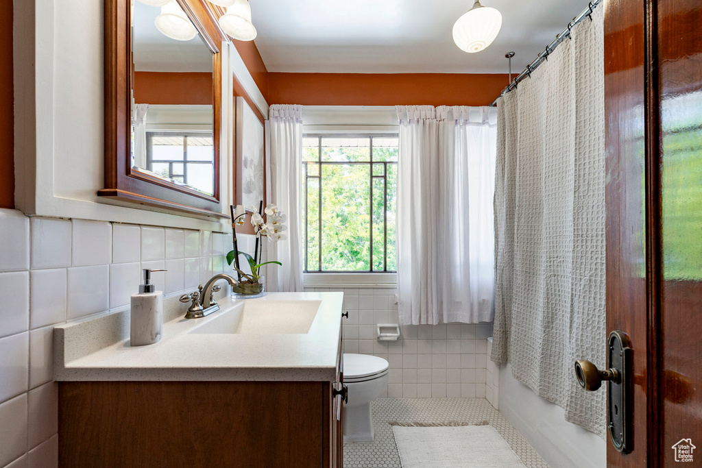 Bathroom featuring tile walls, vanity, tile patterned flooring, and tasteful backsplash