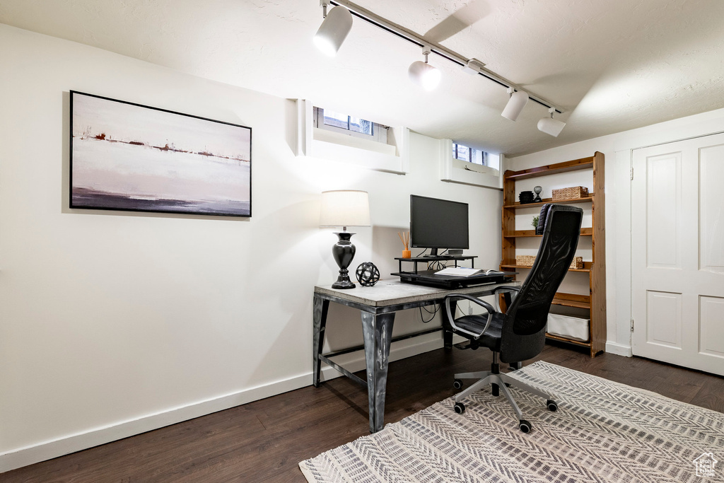 Office area with rail lighting and dark wood finished floors