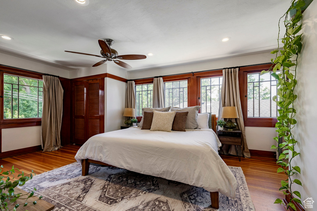 Bedroom with wood finished floors, recessed lighting, a closet, and a ceiling fan
