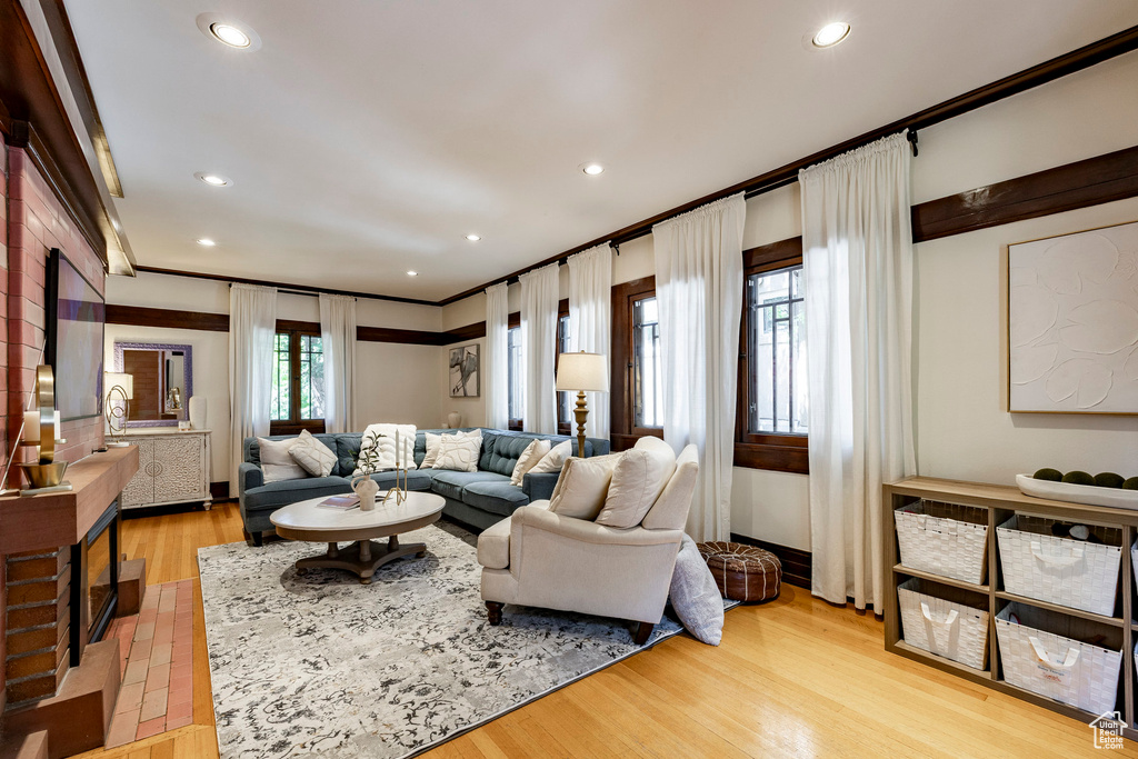 Living area featuring ornamental molding, light wood-style flooring, and recessed lighting