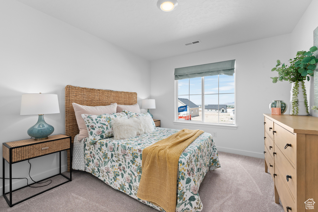 Bedroom featuring light colored carpet and baseboards