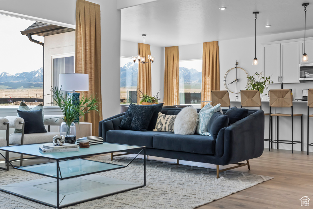 Living room with a mountain view, wood finished floors, a chandelier, and recessed lighting