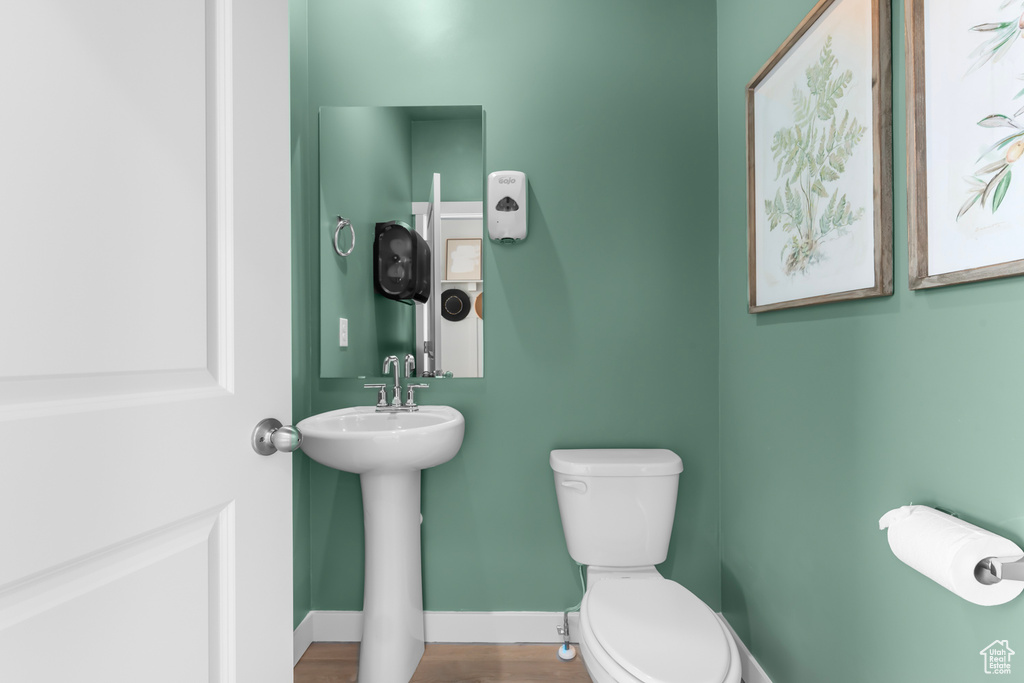 Bathroom featuring toilet, baseboards, and a sink