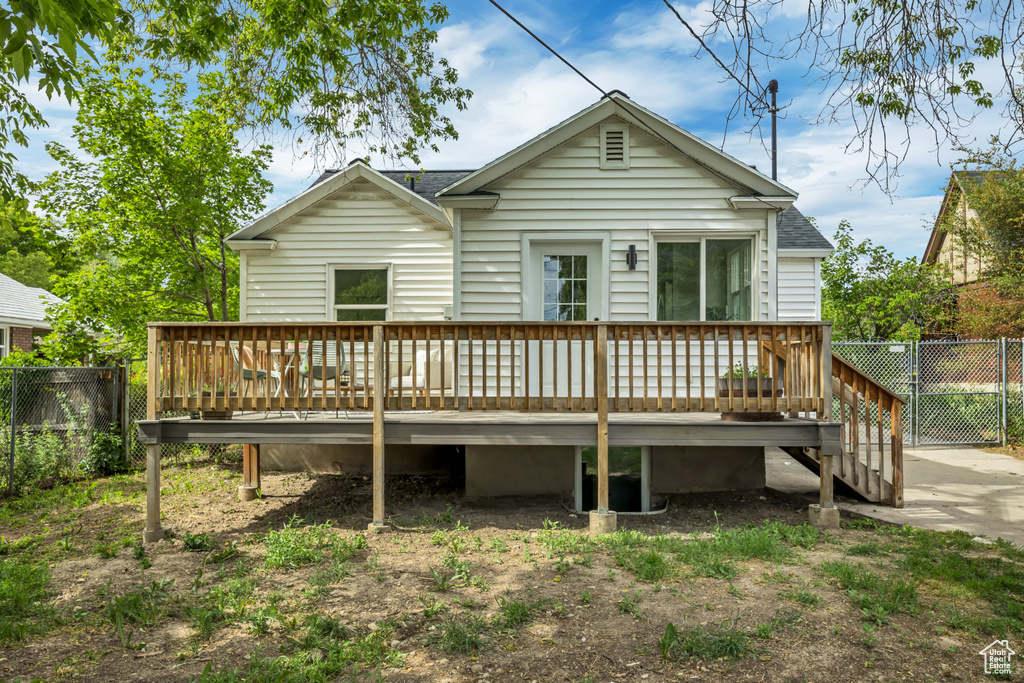 Back of property featuring a wooden deck and roof with shingles