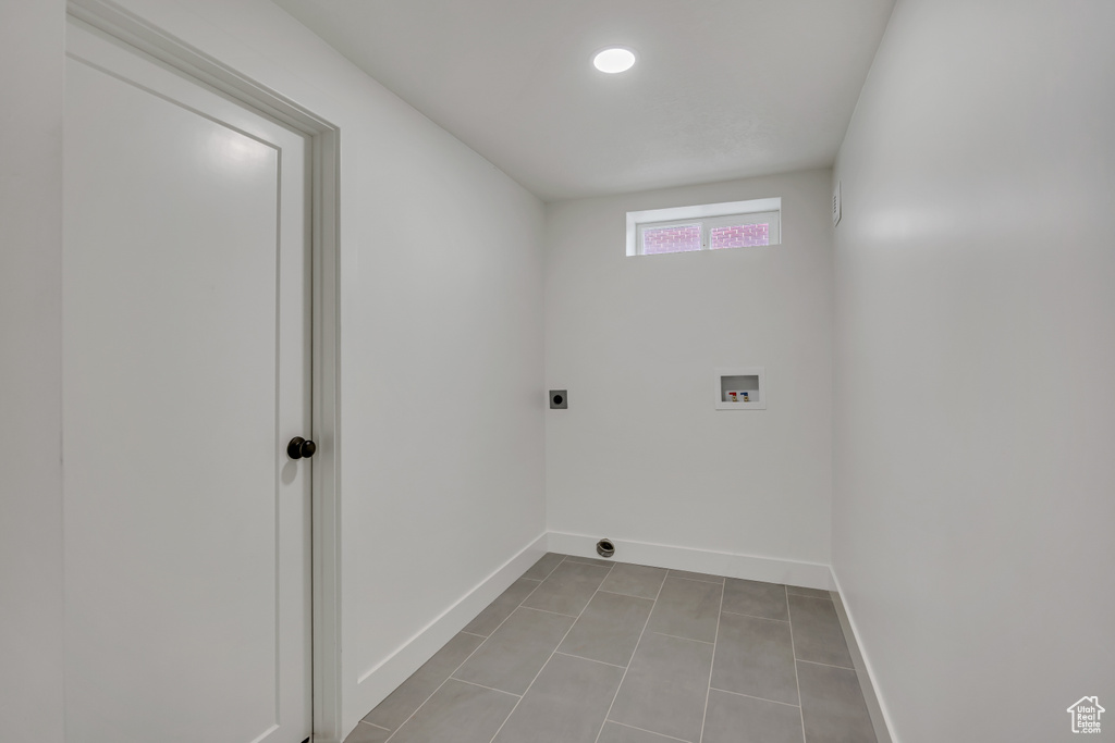Laundry area with hookup for a washing machine, baseboards, electric dryer hookup, and tile patterned flooring