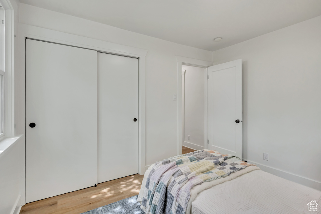 Bedroom with light wood finished floors and a closet