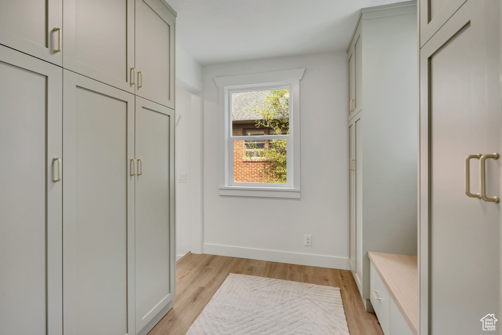 Mudroom featuring light wood-style flooring and baseboards