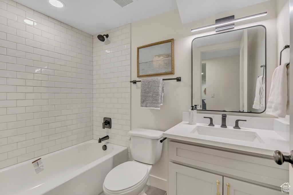 Full bath featuring toilet, vanity, and tub / shower combination