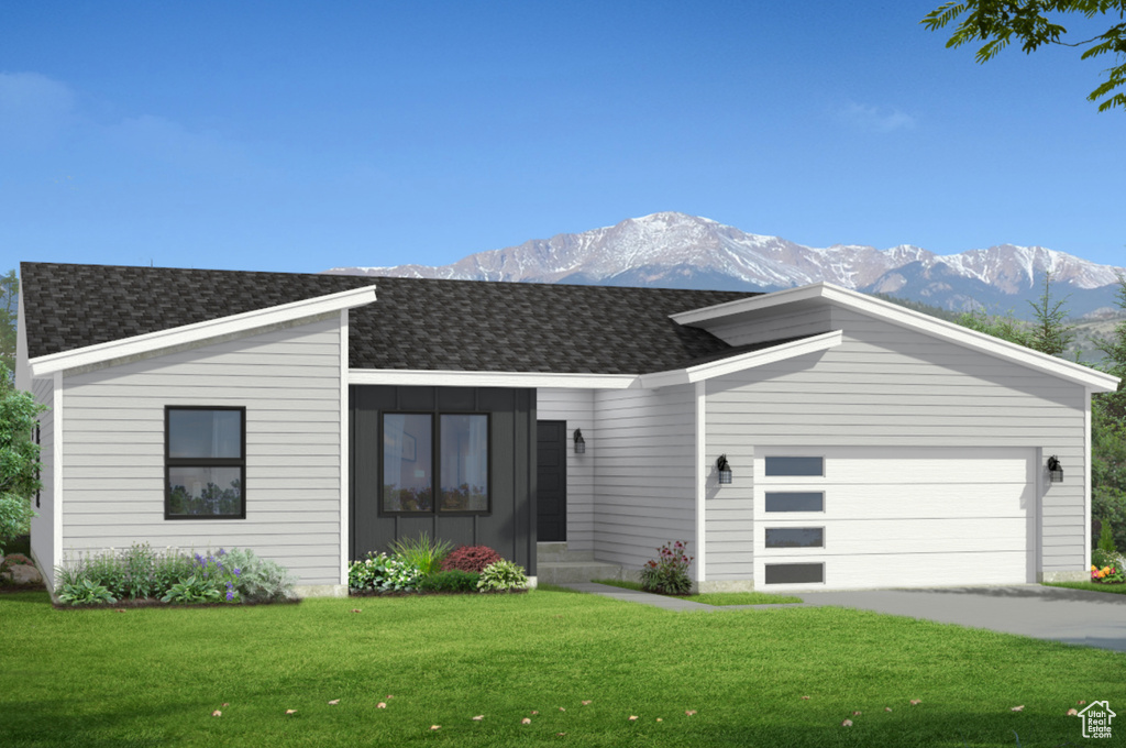 View of front facade featuring a mountain view, a garage, a shingled roof, and a front yard