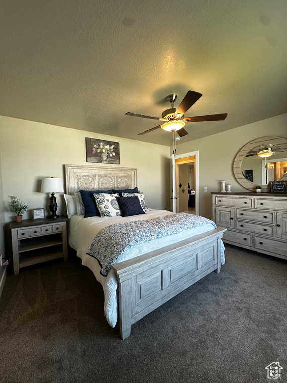 Bedroom featuring dark carpet, a textured ceiling, and ceiling fan