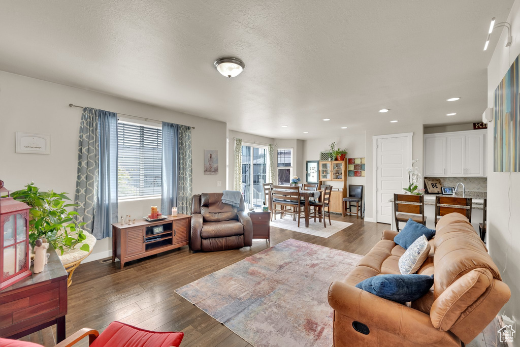 Living area with wood finished floors, recessed lighting, and baseboards