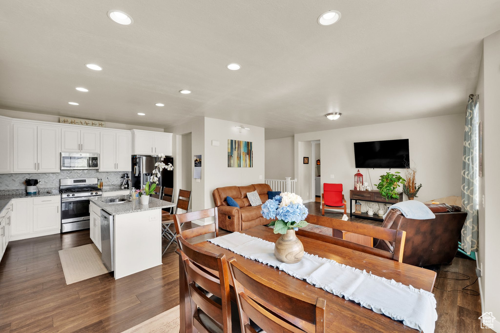 Dining room with recessed lighting and dark wood-style floors