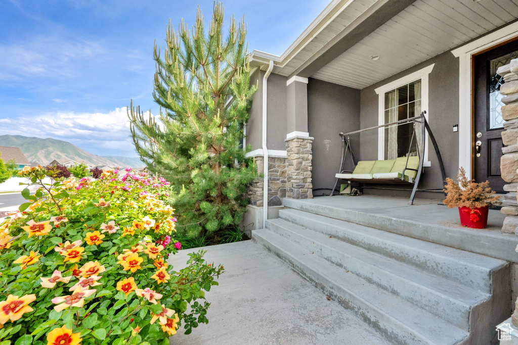 Doorway to property featuring stucco siding, a mountain view, and stone siding