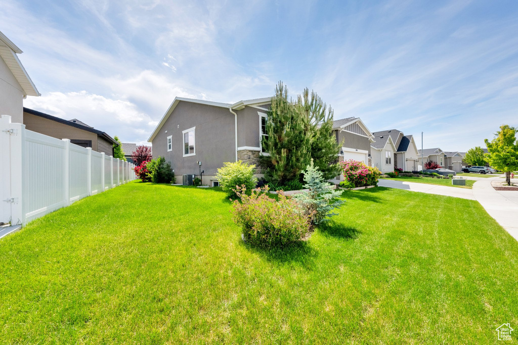 View of home's exterior with a residential view, stucco siding, stone siding, and central AC unit