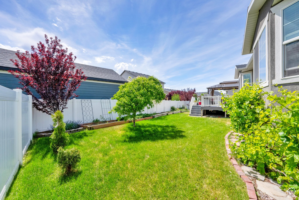 View of yard featuring a wooden deck and stairs