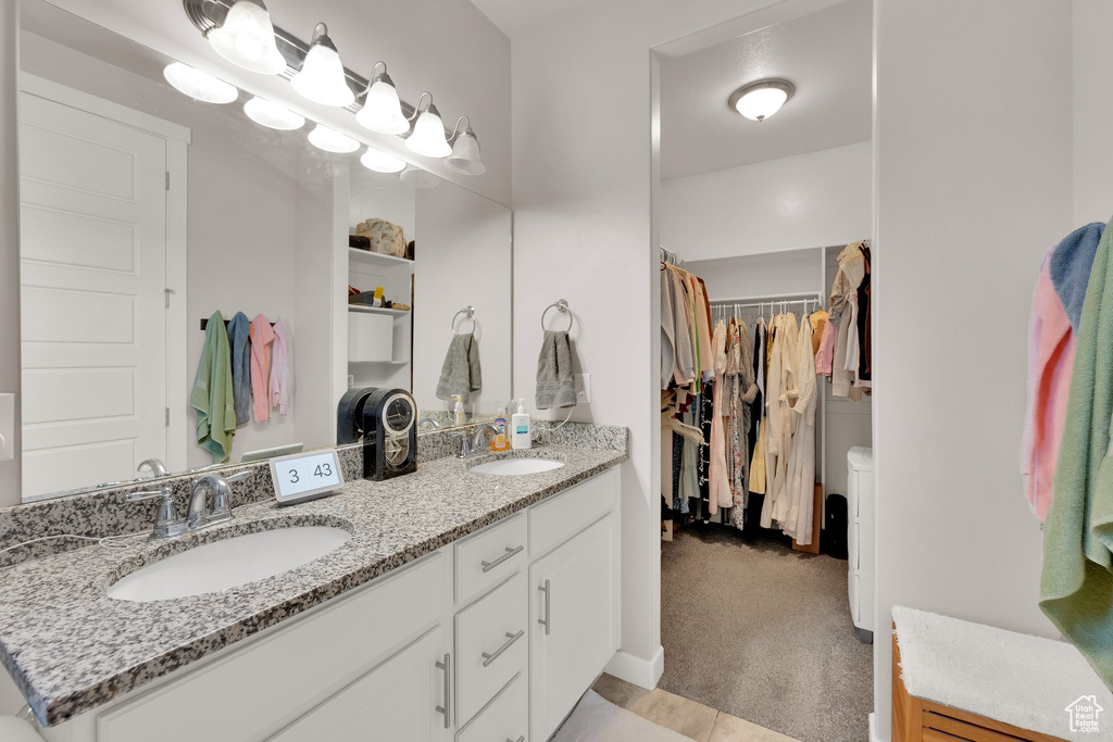 Bathroom featuring double vanity and a spacious closet