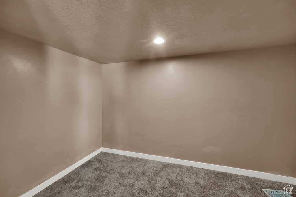 Unfurnished room with dark carpet, baseboards, a textured ceiling, and recessed lighting