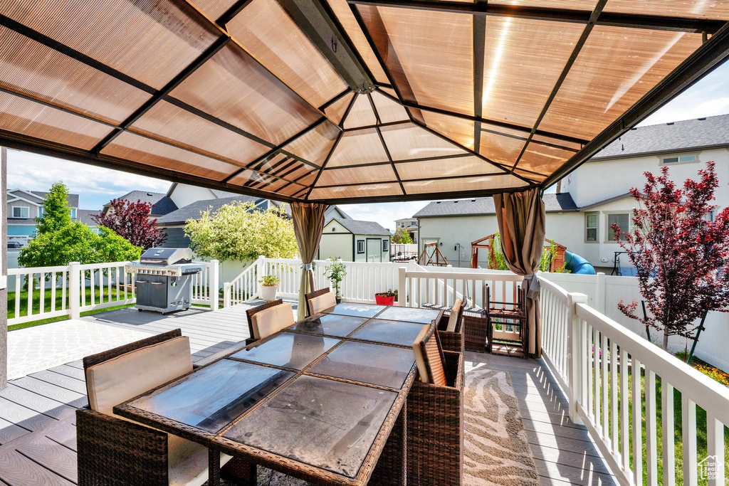 Wooden deck with outdoor dining area, a residential view, area for grilling, and a gazebo
