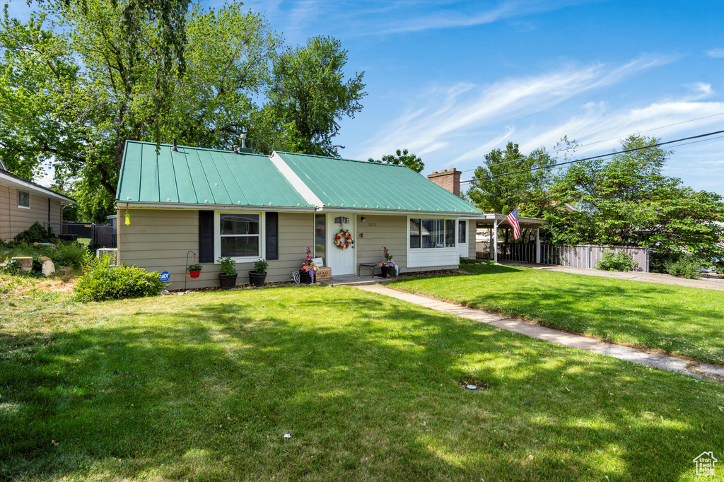 View of front of property with a chimney, metal roof, and a standing seam roof