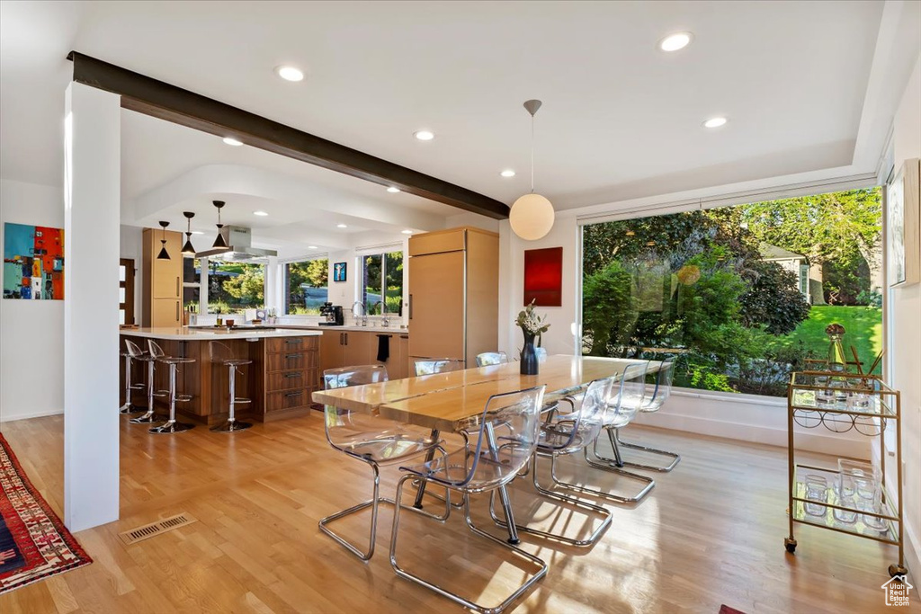 Dining room featuring light wood finished floors, recessed lighting, beamed ceiling, and baseboards