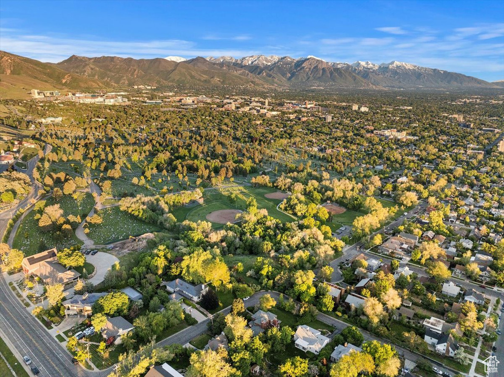 Aerial view of property and surrounding area with mountains and nearby suburban area