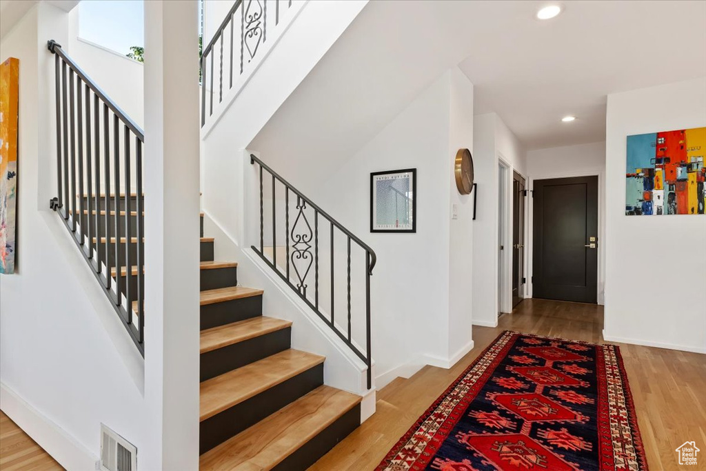 Foyer entrance with recessed lighting, wood finished floors, stairs, and baseboards