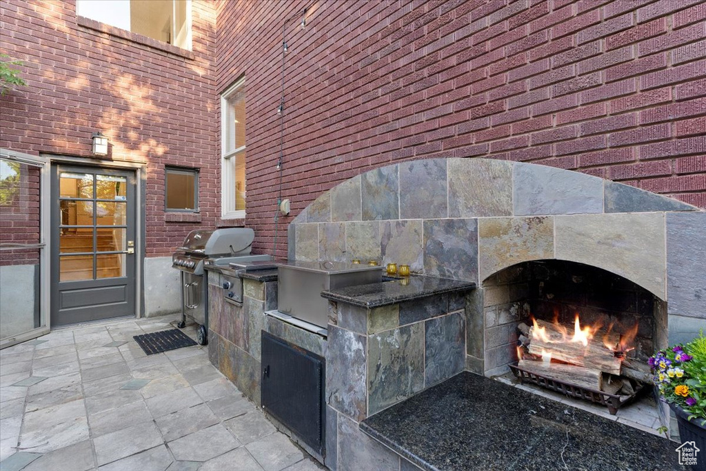 View of patio with a lit fireplace