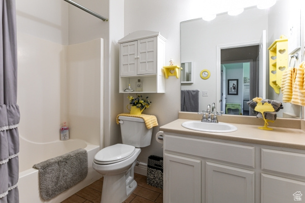 Bathroom with shower / tub combo with curtain, vanity, and toilet