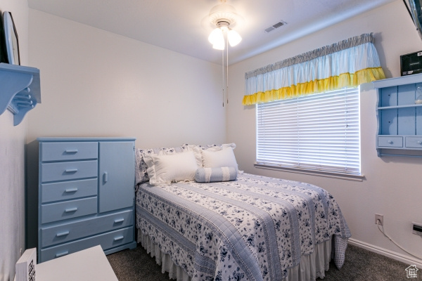 Bedroom featuring dark colored carpet and baseboards