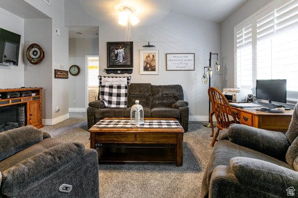 Carpeted living area with baseboards and an office area