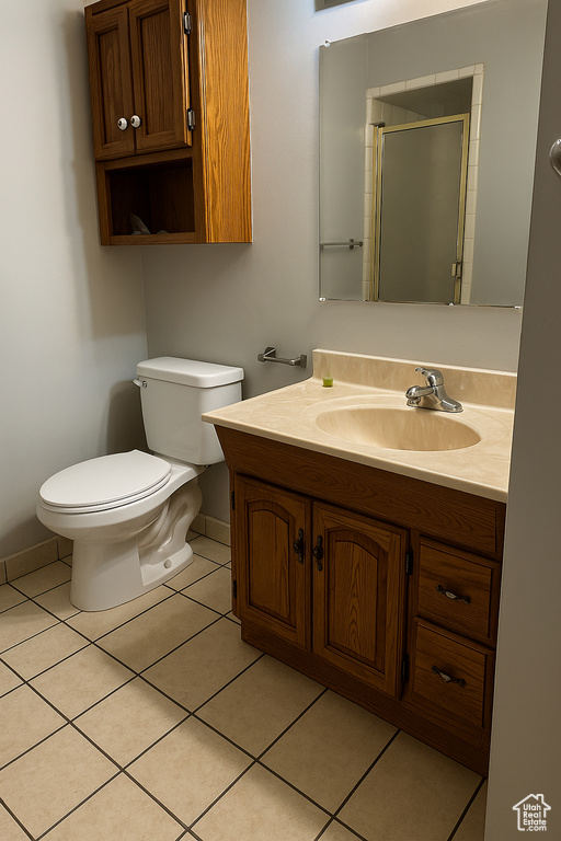 Full bath featuring vanity, baseboards, tile patterned floors, toilet, and a shower with door