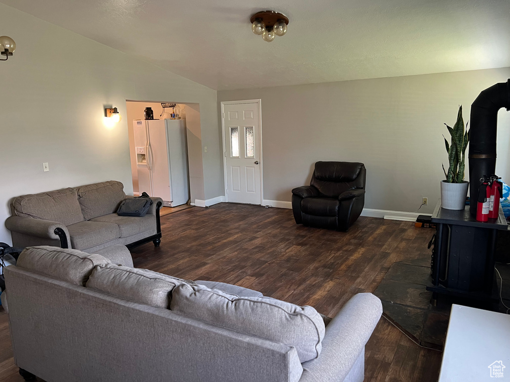 Living room featuring wood finished floors, lofted ceiling, and baseboards