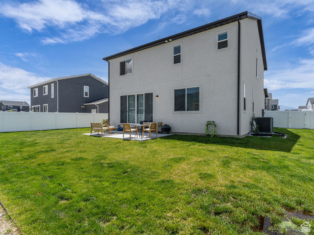 Back of house featuring a patio, stucco siding, outdoor lounge area, and central AC unit