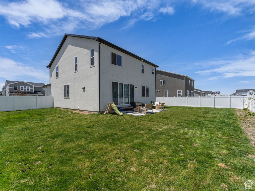Back of house with a patio area, stucco siding, and an outdoor hangout area