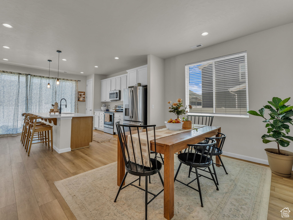 Dining room with recessed lighting, light wood-style flooring, and baseboards