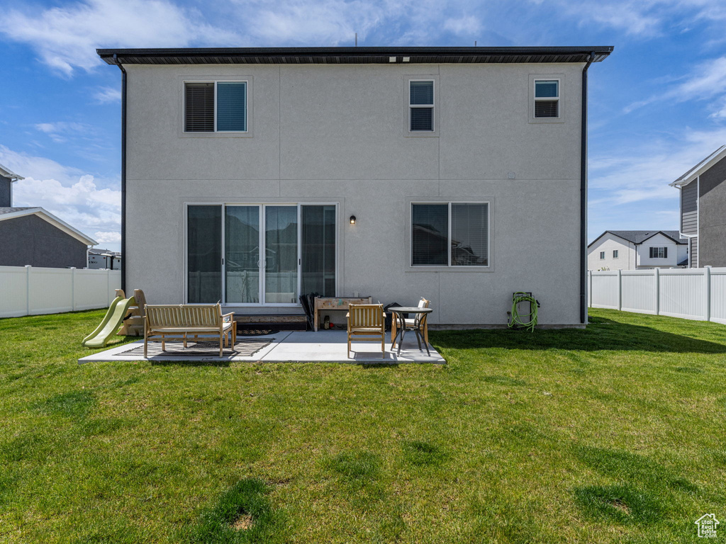 Back of house with a patio area and stucco siding